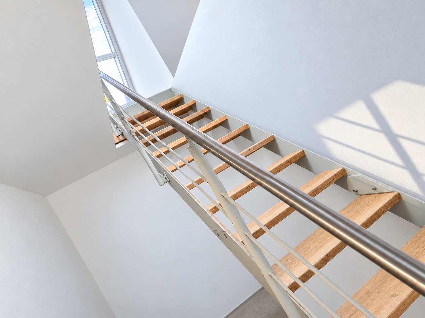 Treppe durch eine rechteckige Deckenöffnung zwischen zwei Geschossen